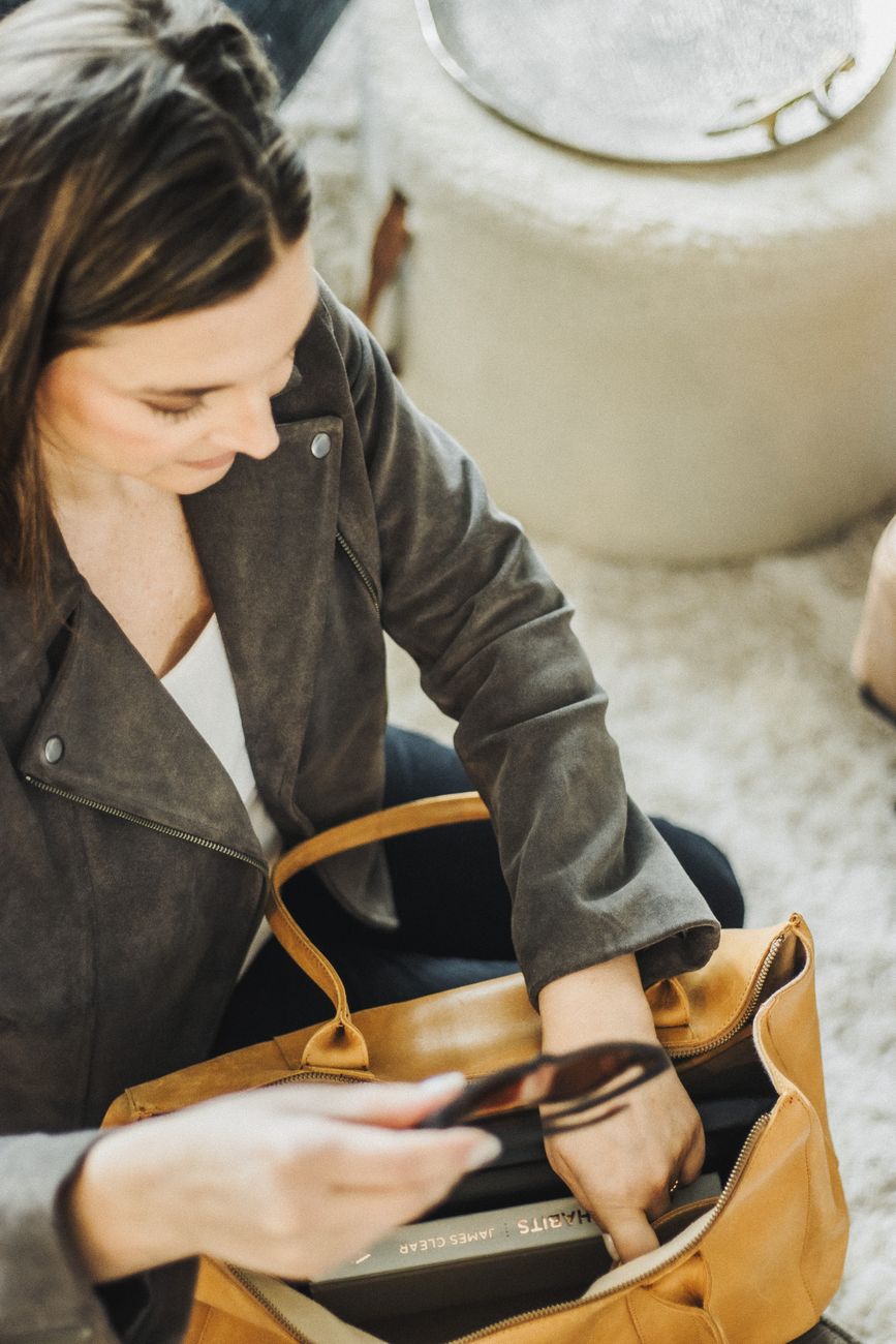 Carefully arranged minimal travel essentials, canvas carry-on and notebook